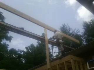 Carpenter setting a ridge beam over a new addition frame — Ice Dam Removal by Roofing Brothers in Liberty Center